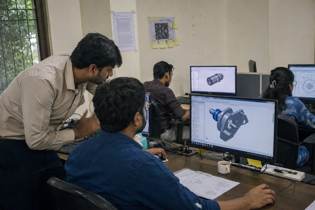CAD trainer guiding a trainee through a 3D assembly model on screen during a CAD training session
